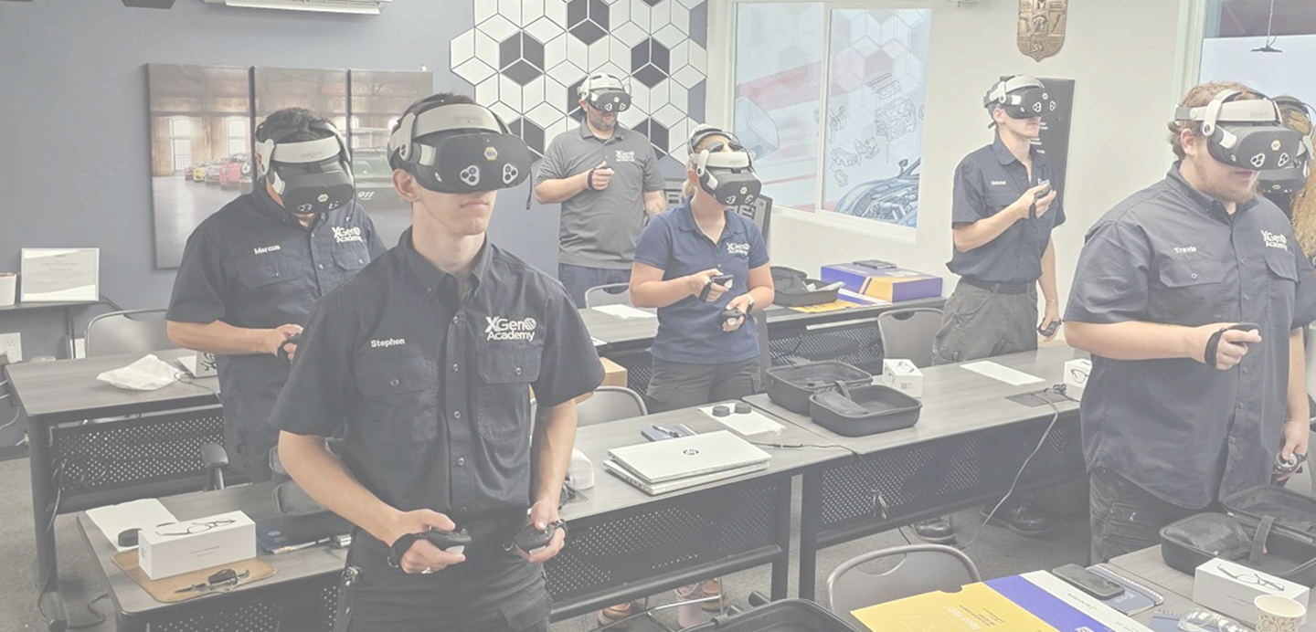 Group of automotive technicians wearing virtual reality headsets and using controllers during training in a classroom.